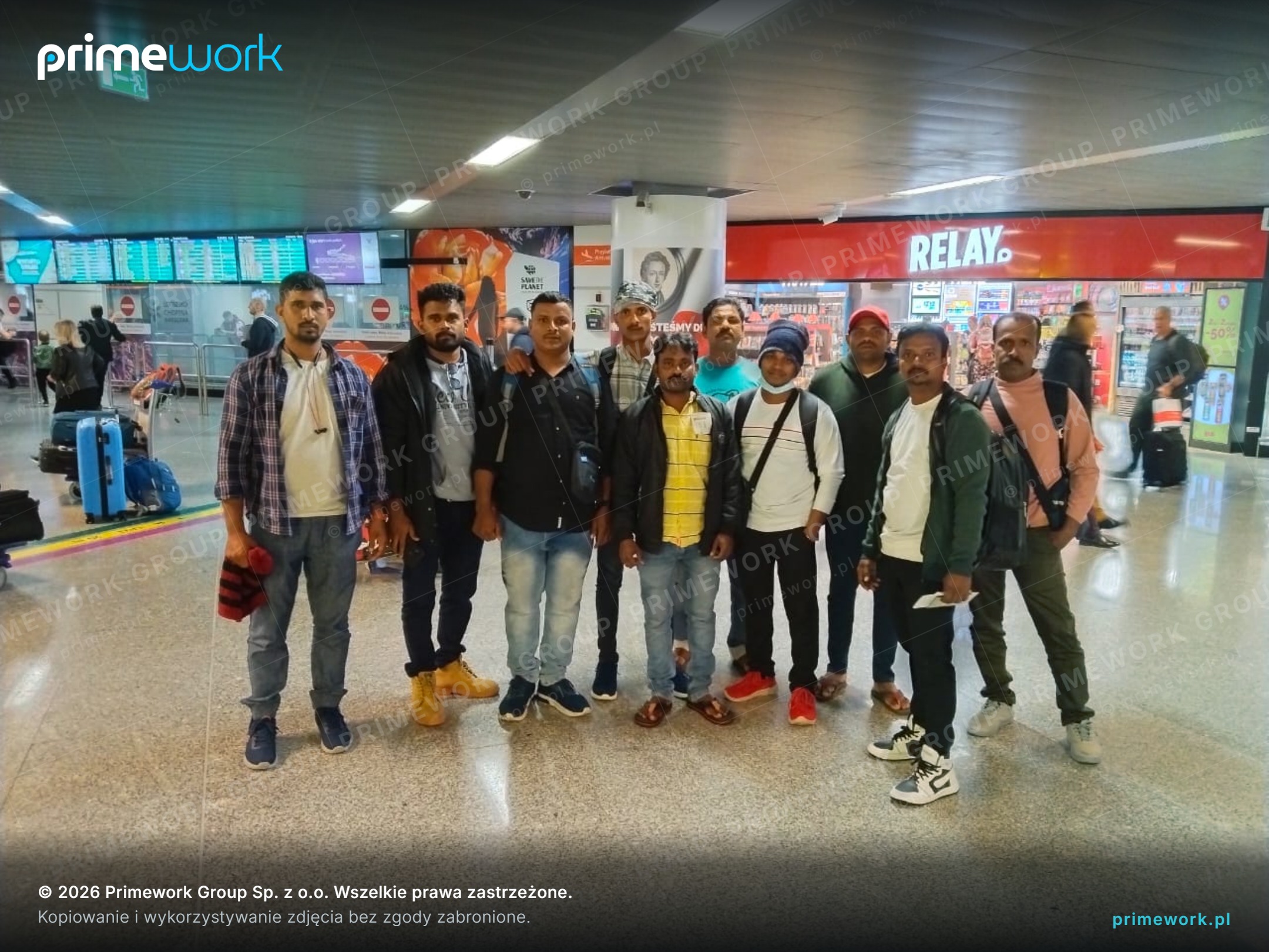 A group of workers from India in the arrivals hall of a Polish airport