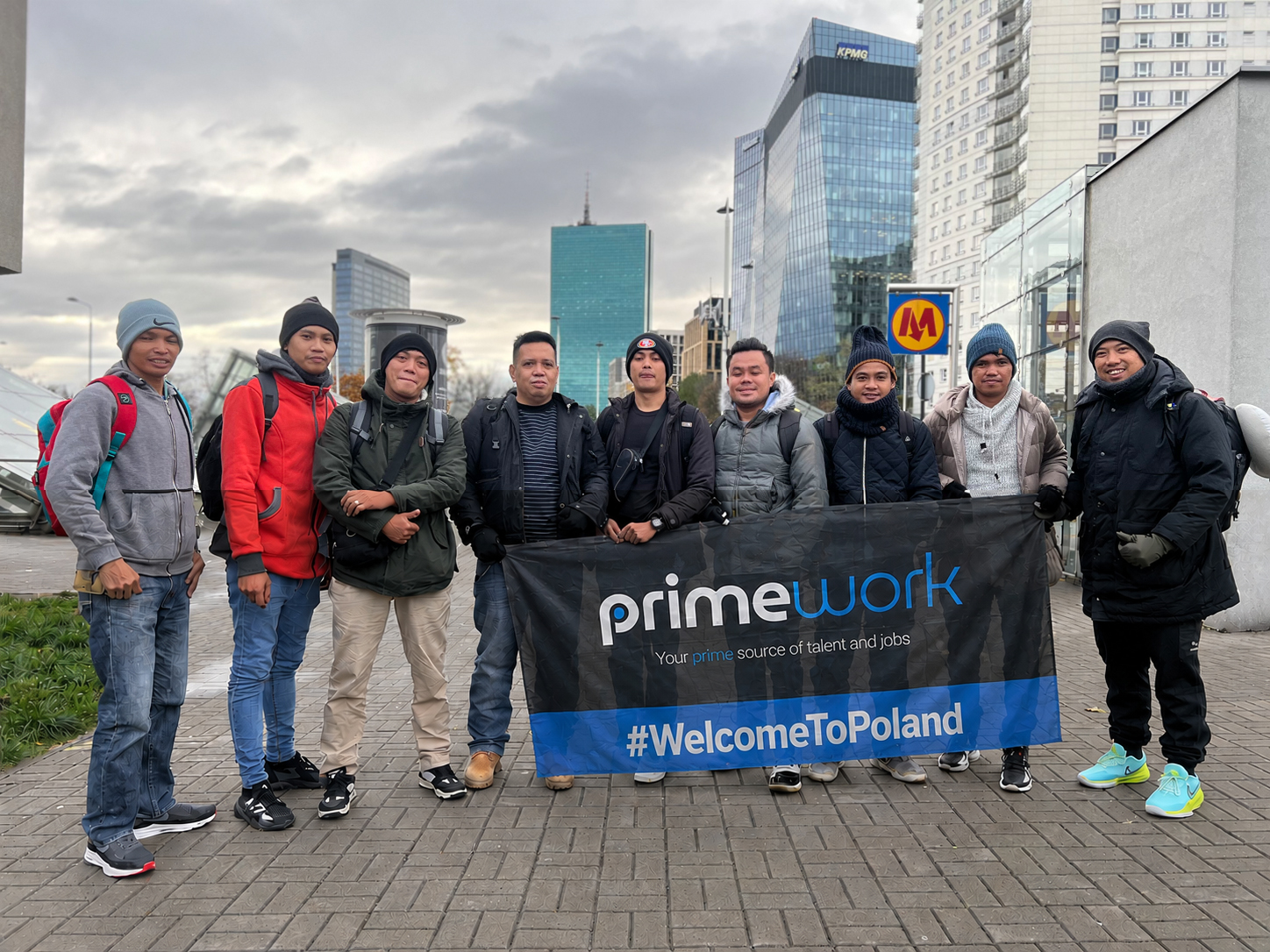 Group of Filipino workers holding a #WelcomeToPoland banner in Warsaw