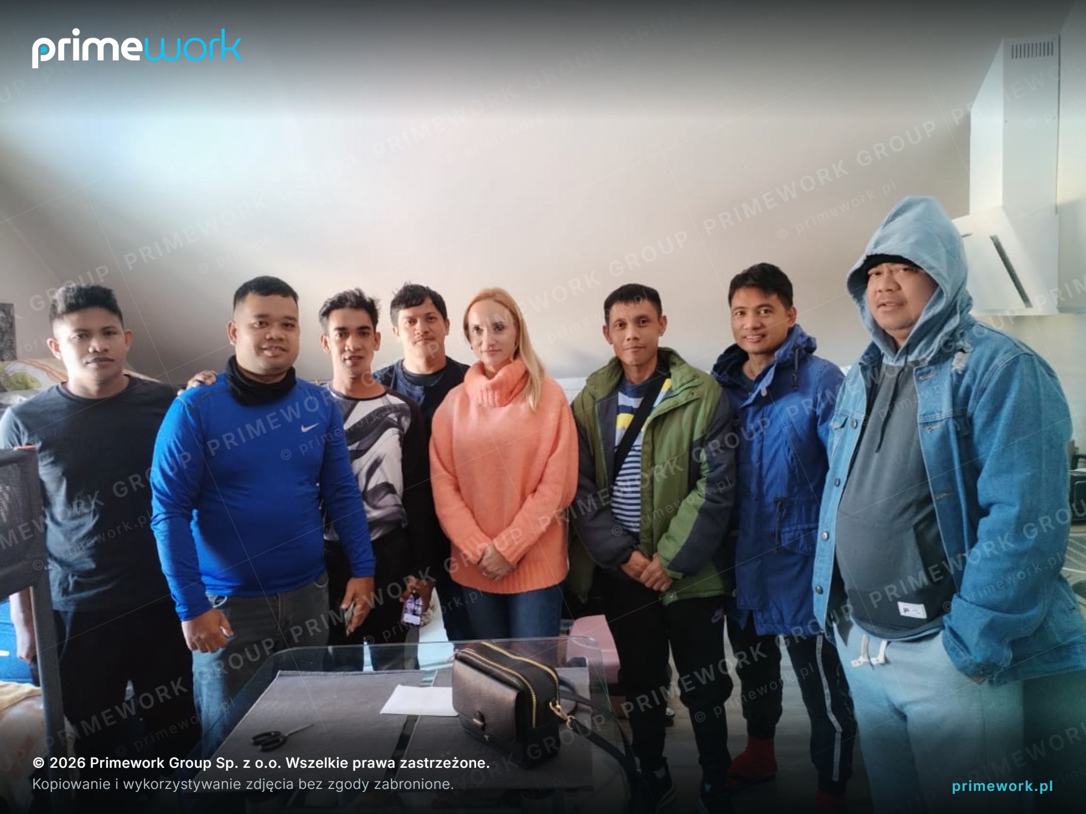 A Primework coordinator with a group of Asian workers during a visit to worker accommodation